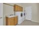Functional laundry room with modern washer and dryer, sink, and storage cabinets at 11017 Meade Ct, Westminster, CO 80031