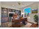 Home office with custom built-ins, a hardwood floor, a large window, and a ceiling fan at 11017 Meade Ct, Westminster, CO 80031