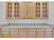 Charming wet bar featuring light wood cabinets, glass doors, and ample counter space for entertaining at 11017 Meade Ct, Westminster, CO 80031