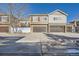 Exterior of townhomes featuring attached garages and varied architectural details at 15444 W 63Rd Ave # 101, Arvada, CO 80403