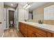 Well-lit bathroom with double sinks, a large mirror, and plenty of cabinet space at 7086 Esperanza Dr, Castle Pines, CO 80108