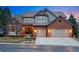 Charming home featuring a red brick facade, neutral siding, a two-car garage, and a meticulously kept lawn at 7086 Esperanza Dr, Castle Pines, CO 80108