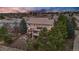 Beautiful exterior view of home with a deck, mature trees, well-manicured landscaping, and a fenced yard at 7086 Esperanza Dr, Castle Pines, CO 80108
