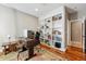 Well-lit home office features custom built-in shelving, hardwood floors, and a comfortable workspace with neutral color palette at 7086 Esperanza Dr, Castle Pines, CO 80108