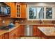 Gourmet kitchen featuring wood cabinets, granite counters, and stainless steel appliances at 7086 Esperanza Dr, Castle Pines, CO 80108