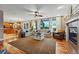 Spacious living room open to the kitchen, featuring large windows and a cozy fireplace at 7086 Esperanza Dr, Castle Pines, CO 80108