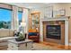 Inviting living room with a fireplace, large windows, and a view of the neighborhood at 7086 Esperanza Dr, Castle Pines, CO 80108