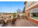Inviting outdoor kitchen with stone accents, built-in grill, and a cozy fire pit on the wood deck, perfect for entertaining at 7086 Esperanza Dr, Castle Pines, CO 80108