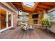 Lovely covered patio with stone fireplace and wood floors, perfect for relaxation and entertaining at 7086 Esperanza Dr, Castle Pines, CO 80108