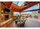 Stunning covered patio with stone fireplace, outdoor kitchen, and scenic views at 7086 Esperanza Dr, Castle Pines, CO 80108