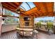 Gorgeous covered patio with a stone fireplace, skylights, and relaxing seating area at 7086 Esperanza Dr, Castle Pines, CO 80108