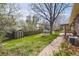 Large backyard features a tool shed, patio, lush grass, mature trees and a brick walkway at 5876 W Canyon Ave, Littleton, CO 80128