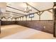 Spacious basement featuring exposed beams, brick accents, carpet flooring, and ample room for activities at 5876 W Canyon Ave, Littleton, CO 80128