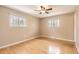 Bright bedroom with hardwood floors, neutral walls, two windows, and a ceiling fan at 5876 W Canyon Ave, Littleton, CO 80128