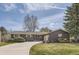 Charming single-story home features a well-manicured lawn, a circular driveway, and a two-car garage at 5876 W Canyon Ave, Littleton, CO 80128