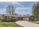 Charming single-story home features a well-manicured lawn, a circular driveway, and a two-car garage at 5876 W Canyon Ave, Littleton, CO 80128