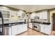 Bright kitchen with white cabinets, stainless steel appliances, granite countertops, and wooden flooring at 5876 W Canyon Ave, Littleton, CO 80128