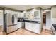 Bright kitchen featuring white cabinets, stainless steel appliances, granite countertops, and wooden flooring at 5876 W Canyon Ave, Littleton, CO 80128