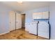 Bright laundry room features wood floors, washer, dryer and white storage cabinets for a convenient space at 5876 W Canyon Ave, Littleton, CO 80128