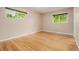 This bedroom has hardwood floors and large windows overlooking a green landscape at 8231 E Lehigh Dr, Denver, CO 80237
