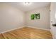 Cozy bedroom featuring gleaming hardwood floors, neutral paint, and a bright window at 8231 E Lehigh Dr, Denver, CO 80237