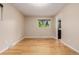 This bedroom has hardwood floors, neutral walls and a large window overlooking nature at 8231 E Lehigh Dr, Denver, CO 80237