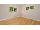 Bright bedroom with hardwood floors, neutral walls, and large windows with green view at 8231 E Lehigh Dr, Denver, CO 80237
