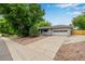 Charming single-story home with a two-car garage and mature trees in a well-maintained front yard at 8231 E Lehigh Dr, Denver, CO 80237