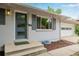 Charming blue front door with brick facade, lush landscaping, and eye-catching curb appeal at 8231 E Lehigh Dr, Denver, CO 80237