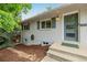 Charming blue front door with brick facade, lush landscaping, and eye-catching curb appeal at 8231 E Lehigh Dr, Denver, CO 80237