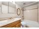 Bathroom with white tiled shower/tub, light countertops, wood vanity and a large framed mirror, offering a clean and bright space at 2231 S Vaughn Way # 205B, Aurora, CO 80014