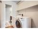 Laundry area featuring a modern washer and dryer, shelving, and an adjacent bathroom, providing convenience and functionality at 2231 S Vaughn Way # 205B, Aurora, CO 80014