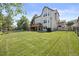 Large lawn and rear elevation of home with deck overlooking treed perimeter at 10 Sand Cherry, Littleton, CO 80127