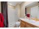 Bright bathroom features a tiled shower, neutral paint, and wood vanity at 10 Sand Cherry, Littleton, CO 80127