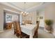 Formal dining room with a classic chandelier, seating for six, and a view of the outdoors at 10 Sand Cherry, Littleton, CO 80127