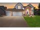 Charming two-story home with brick and siding, three-car garage, manicured lawn, and front patio at 10 Sand Cherry, Littleton, CO 80127