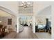 Bright, open foyer with hardwood floors, a grand staircase, chandelier and views into the living spaces at 10 Sand Cherry, Littleton, CO 80127