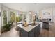 Bright kitchen showcases an island cooktop, with views into the living room with a cozy breakfast nook at 10 Sand Cherry, Littleton, CO 80127