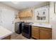Laundry room with stainless washer and dryer, built-in sink and cabinets at 10 Sand Cherry, Littleton, CO 80127