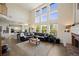 Open living room featuring soaring ceilings, a brick fireplace, and a seamless transition to the kitchen at 10 Sand Cherry, Littleton, CO 80127