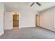 Spacious bedroom with neutral carpet, a ceiling fan, and two open doors, one leading to a bathroom at 1840 Irving St, Denver, CO 80204