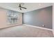 Bright bedroom with a ceiling fan, carpeted floors, and a large window allowing natural light to fill the room at 1840 Irving St, Denver, CO 80204