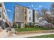 Modern home featuring a manicured lawn, garden border, and covered parking with blue skies above at 1840 Irving St, Denver, CO 80204
