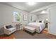 Bright bedroom featuring a queen-sized bed, hardwood floors, and a seating area with a comfortable chair at 5240 Dudley St, Arvada, CO 80002