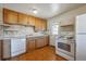 Retro kitchen with white appliances, light wood cabinetry, and vintage style flooring at 5240 Dudley St, Arvada, CO 80002