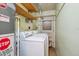 A laundry room with washer, dryer, and exposed shelving at 5240 Dudley St, Arvada, CO 80002