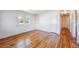 An empty room with light streaming in a window and hardwood floors at 5240 Dudley St, Arvada, CO 80002