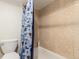 Cozy bathroom showcasing tile walls, white fixtures, and a blue floral shower curtain at 1833 N Williams St # 101, Denver, CO 80218