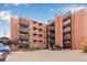 Brick apartment building with black metal balconies and well maintained landscaping offers urban living at 1833 N Williams St # 101, Denver, CO 80218