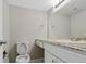 Bright bathroom with a large mirror, granite countertops, and white cabinets provides a clean, modern feel at 14046 E Stanford Cir # I04, Aurora, CO 80015